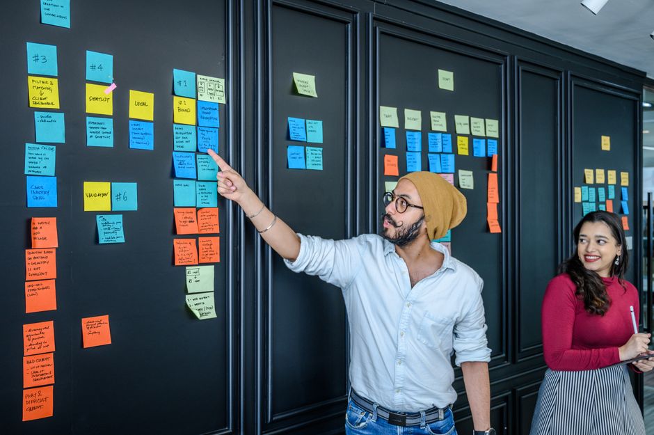 Colorful sticky notes with ideas and keywords, some labeled 'context', 'role', 'format', on a whiteboard, representing brainstorming and prompt structure.