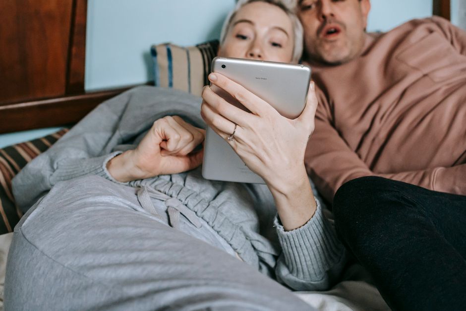 A family gathered on a sofa, happily watching a movie on a tablet, demonstrating its use for entertainment and shared experiences.