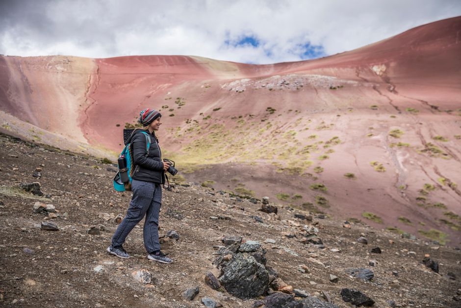 A solo hiker with a backpack on a trail in the majestic Andes mountains, illustrating a journey through high-altitude terrain.